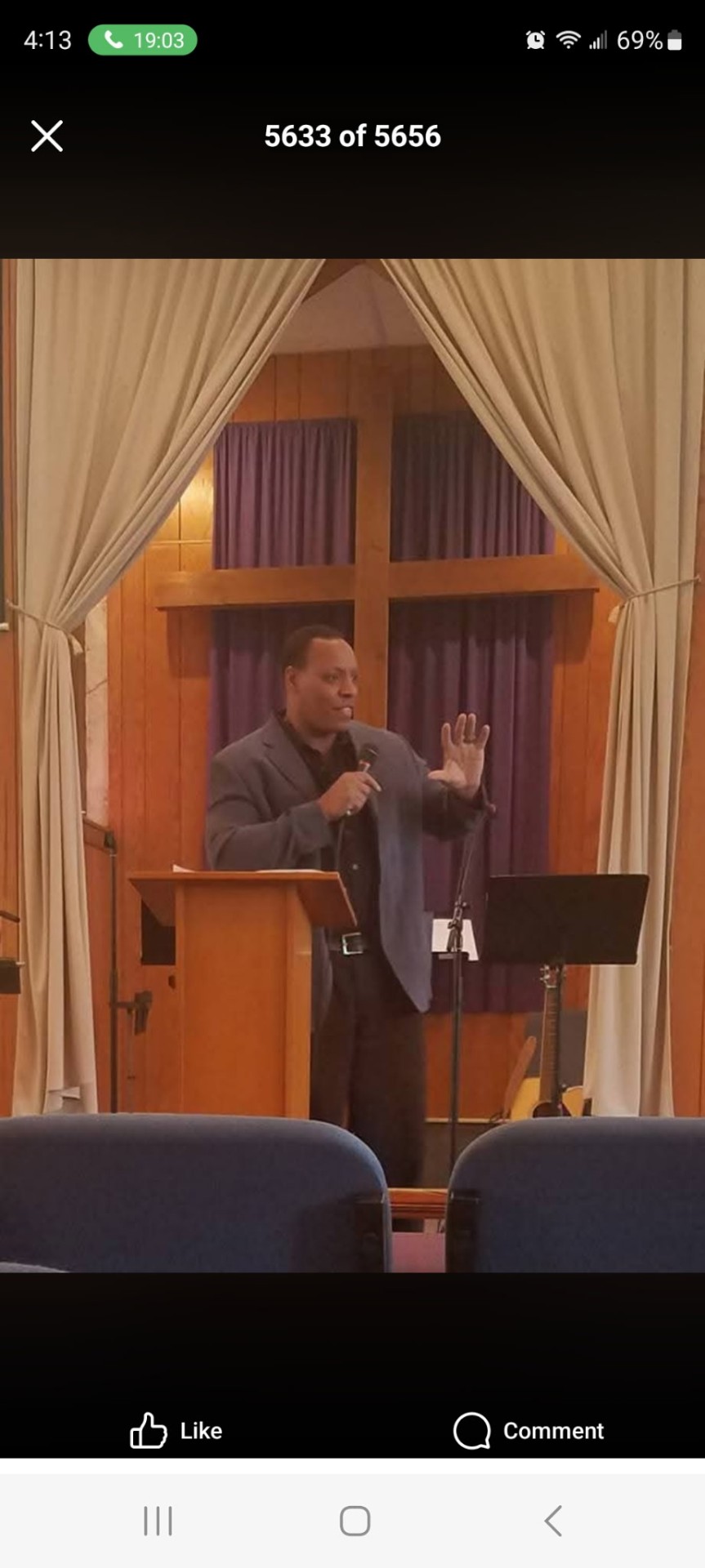 Dr. David Green speaking from a wooden podium during a human services leadership keynote.